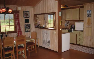 a kitchen and dining room with a table and a refrigerator at Holiday Home Hemsedal Rusto Raunhaug in Hemsedal