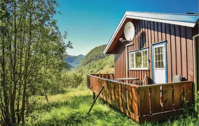 a small red house with a large wooden deck at Beitebu in Hemsedal