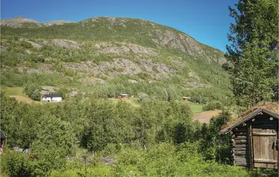 a mountain in the distance with houses and a cabin at Vinjebu in Hemsedal