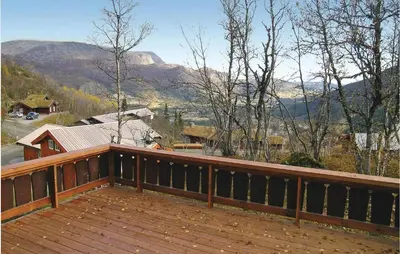 a large wooden deck with a view of mountains at Holiday Home Hemsedal Høgeloft in Hemsedal