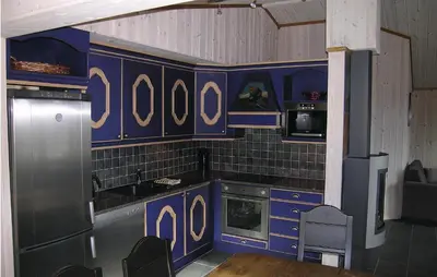 a kitchen with blue cabinets and a table and chairs at Holiday Home Hemsedal Høgeloft in Hemsedal