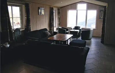 a living room with couches and a table and windows at Holiday Home Hemsedal Høgeloft Ii in Hemsedal