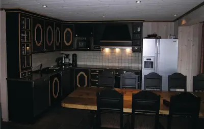 a kitchen with a table and a white refrigerator at Holiday Home Hemsedal Høgeloft Ii in Hemsedal