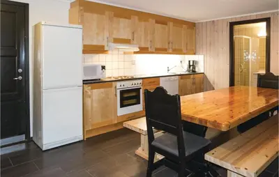 a kitchen with a wooden table and a white refrigerator at Gorgeous Apartment In Hemsedal in Hemsedal