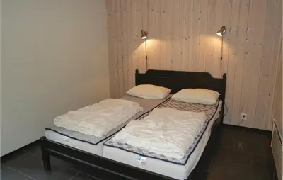 two twin beds in a room with wooden walls at Gorgeous Apartment In Hemsedal in Hemsedal