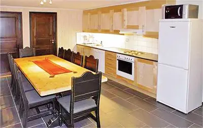 a kitchen with a table and a white refrigerator at Gorgeous Apartment In Hemsedal in Hemsedal