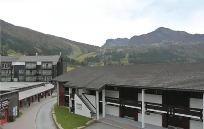 a group of buildings with mountains in the background at Gorgeous Apartment In Hemsedal in Hemsedal