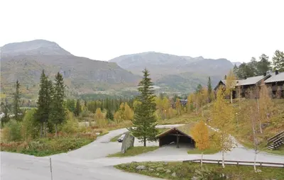 a road with a house and mountains in the background at Nice Apartment In Hemsedal With Sauna in Hemsedal