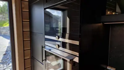 a black oven with a window in a kitchen at Mlodge - The Mountain Lodge in Sogndal