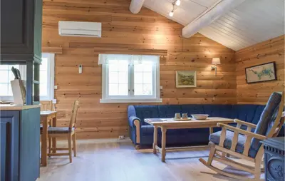 a living room with a blue couch and a table at Sundflathytta in Nesland