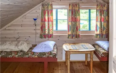 a room with a bed and a table and windows at Holiday Home Vinje Skjærdalen