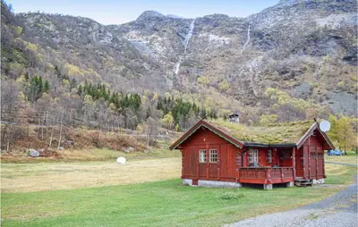 a red house with a grass roof on a field at Awesome Home In Rauland With Kitchen in Rauland
