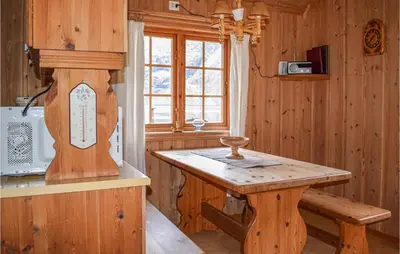 a wooden kitchen with a wooden table and a window at Awesome Home In Rauland With Kitchen in Rauland