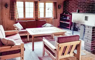 a living room with a couch and a table and a fireplace at Holiday Home Hurdal Steinsjøveien in Hurdal