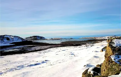 a beach covered in snow with mountains in the background at Holiday Home Vallersund Nausthylla Haldorhamn in Valsøya