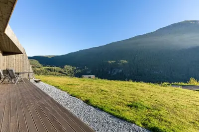 a wooden deck with chairs on top of a mountain at Sogndal Fjordpanorama in Sogndal