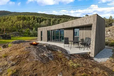 a small wooden house on a hill with a fire at Sogndal Fjordpanorama in Sogndal