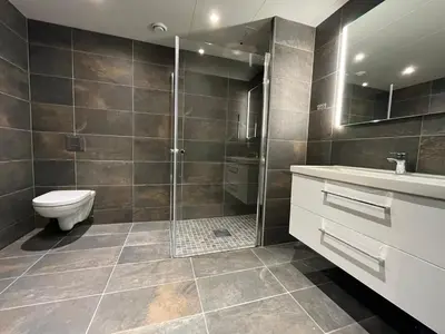 a bathroom with a shower and a toilet and a sink at Trysil Alpine Lodge in Trysil