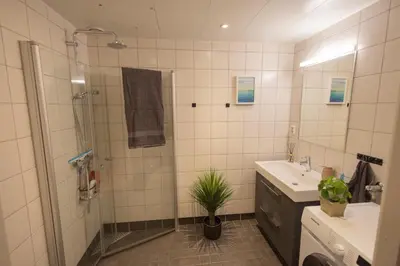 a bathroom with a shower and a sink and a mirror at Modern Apartment - Amazing Terrace and Fjord View, Close to City Center in Bergen
