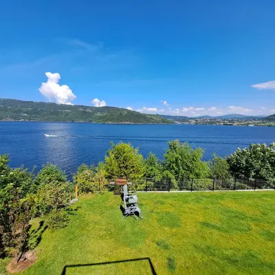 a motorcycle parked on the grass next to a lake at Bergen sunrise Apartment - self check in - Free Parking in Bergen