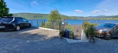 two cars parked in a parking lot next to a body of water at Bergen sunrise Apartment - self check in - Free Parking in Bergen