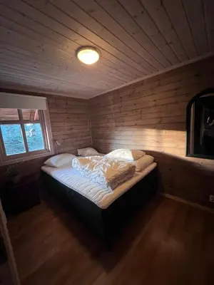 a bedroom with a bed in a wooden room at Hytto in Håra