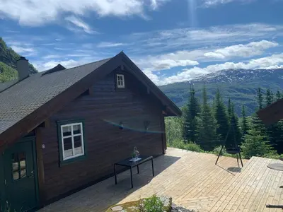 a cabin with a deck and a view of the mountains at Hytto in Håra