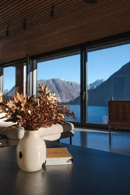 a vase with a plant on a table with a book at VILLA KRISTINA / ÅNDALSNES in Torvik