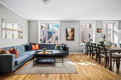 a living room with a blue couch and a table at Dragesmauet Apartments in Bergen