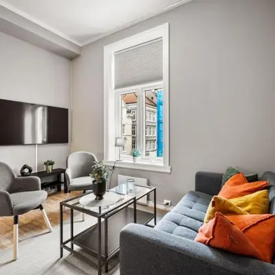 a living room with a blue couch and a table at Rosen Apartment in Bergen