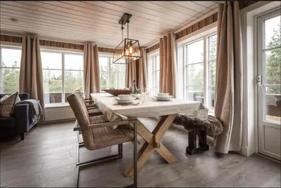 a dining room with a table and some windows at Cabin with sauna in Trysil in Trysil