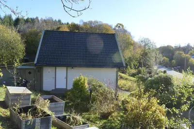 a small white house with a black roof at Guesthouse in Manger, Radøy Island in Kollstad