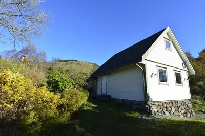 a small white house with a roof at Guesthouse in Manger, Radøy Island in Kollstad