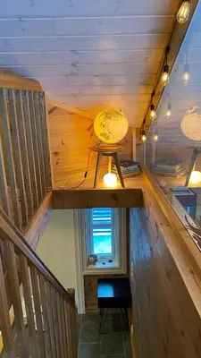 a wooden staircase with a light and a window at Penthouse by the ski lift, 4 bedrooms, 2 living rooms in Stranda