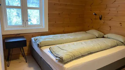 a bed in a wooden room with a window at Penthouse by the ski lift, 4 bedrooms, 2 living rooms in Stranda