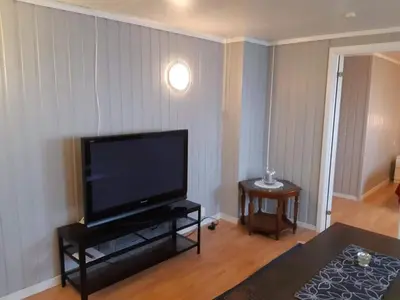 a living room with a large flat screen tv at Fjord side apartment in Jondal