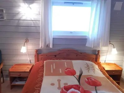 a bedroom with a bed with red flowers on it at Fjord side apartment in Jondal