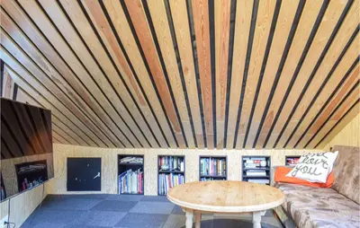 a room with a wooden ceiling with a couch and a table at 4 Bedroom Gorgeous Home In Erfjord in Erfjord