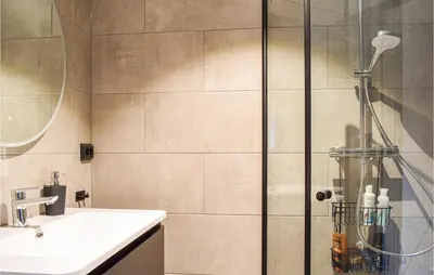 a bathroom with a shower with a sink and a mirror at 4 Bedroom Gorgeous Home In Erfjord in Erfjord