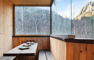 a room with a large window and a wooden table at 4 Bedroom Gorgeous Home In Erfjord in Erfjord