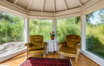 two chairs and a table in a room with windows at Amazing Home In Skjoldastraumen in Skjoldastraumen