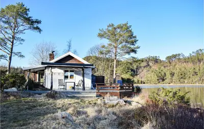 a small house next to a body of water at Lovely Home In Bjoa With Kitchen in Utbjoa