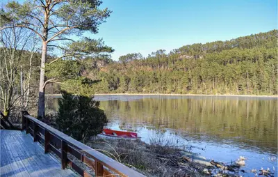 a boat sitting on the shore of a lake at Lovely Home In Bjoa With Kitchen in Utbjoa