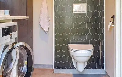 a bathroom with a toilet and a washing machine at 5 Bedroom Lovely Home In Bjoa in Utbjoa