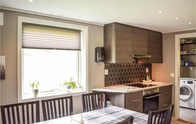 a kitchen with a table and chairs and a window at 5 Bedroom Lovely Home In Bjoa in Utbjoa