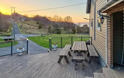 a wooden deck with a picnic table on a building at 5 Bedroom Lovely Home In Bjoa in Utbjoa