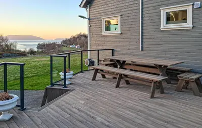 a wooden deck with a picnic bench on the side of a house at 5 Bedroom Lovely Home In Bjoa in Utbjoa
