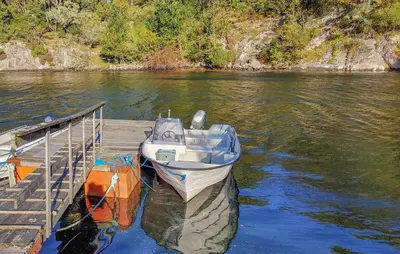 a boat is docked at a dock on a river at Gorgeous Home In Reksteren With Kitchen in Hope