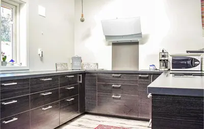 a kitchen with dark wood cabinets and a sink at Amazing Home In Etne With Wifi in Erve