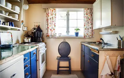 a kitchen with blue cabinets and a window at Gorgeous Home In Reksteren With Kitchen in Klinkholmen